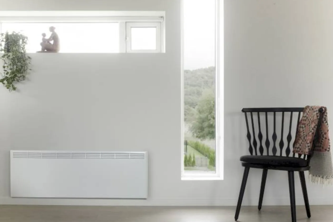 Bijeli panelni radijator u svijetloj sobi