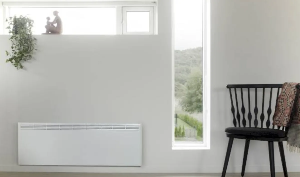 Bijeli panelni radijator u svijetloj sobi